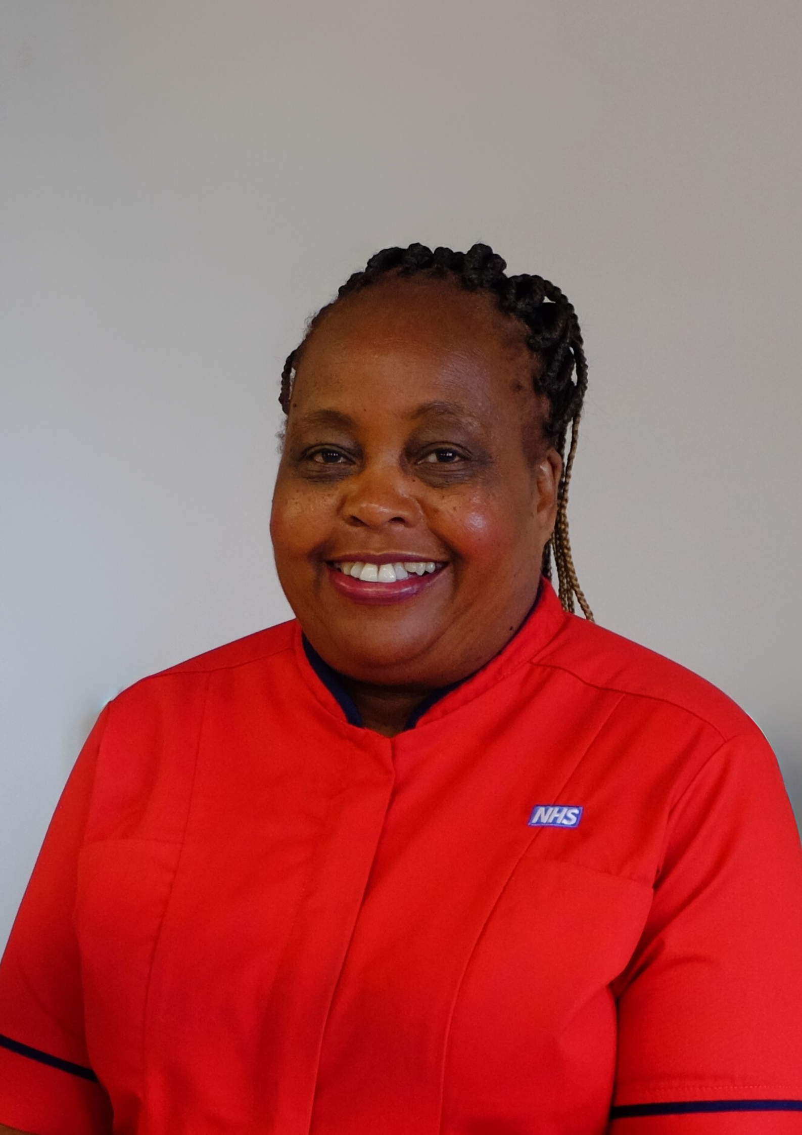 Tabetha Darmon, Chief Nursing Officer of Morecambe Bay NHS Trust, standing in red uniform against a white background