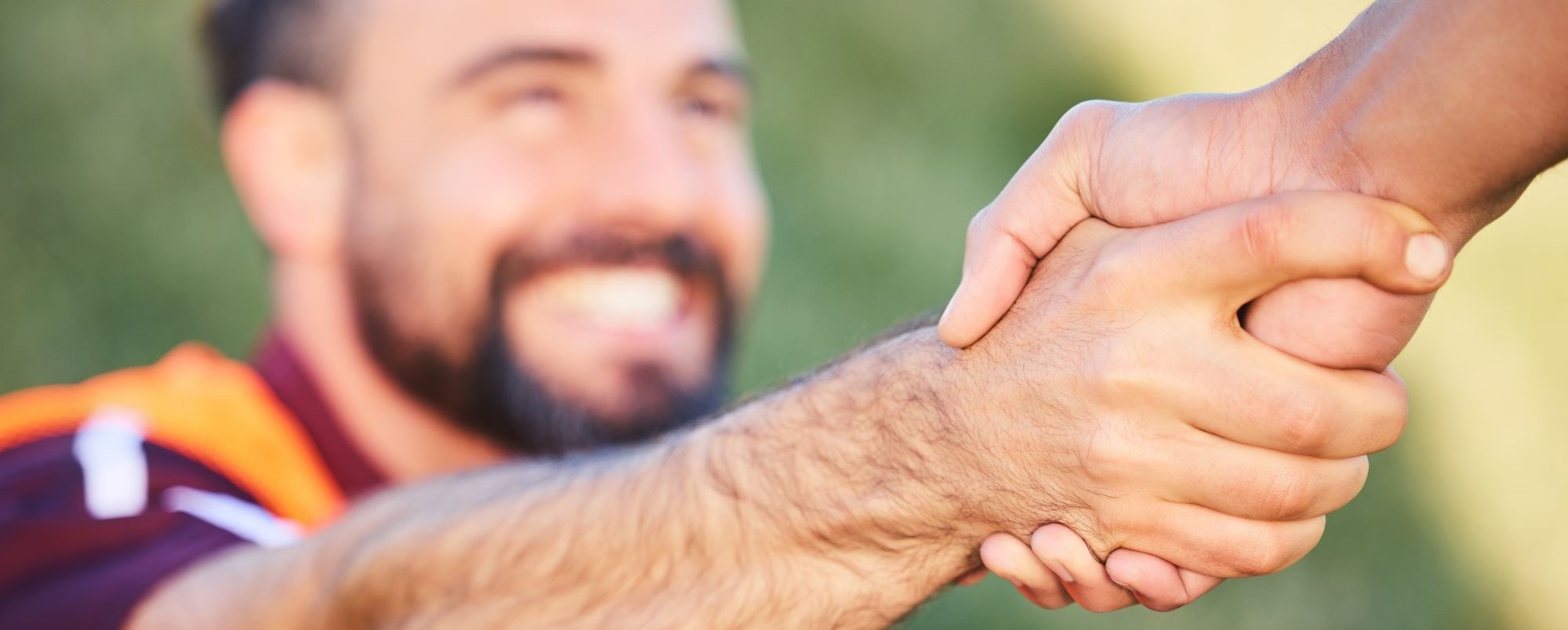 Blurred image of two rugby players shaking hands