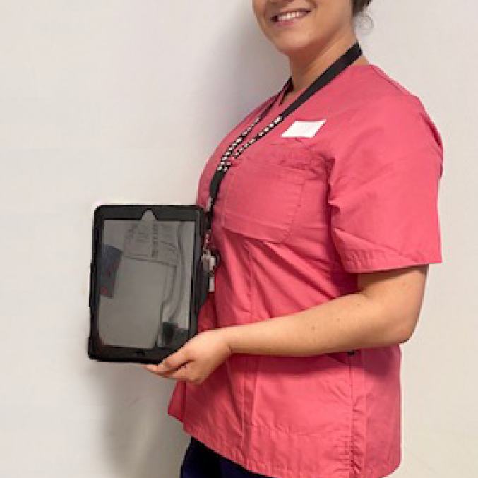 A member of staff at UHMBT holding up one of the new iPads.png